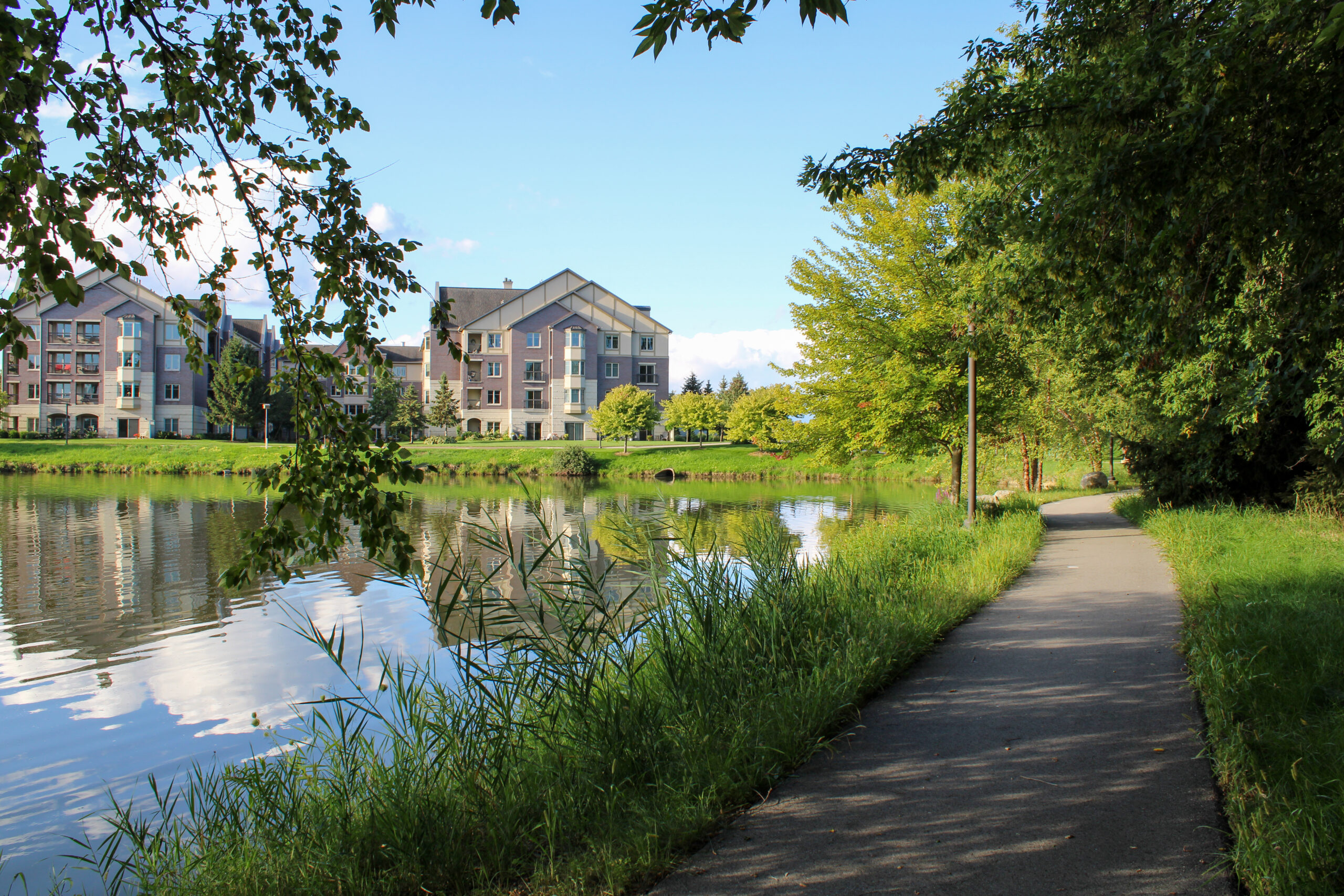 WP Outdoor Photos-45 Image of a building and lake on a walking trail with greenery.